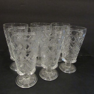 Puede incluir: Juego de seis vasos para beber de vidrio transparente con un diseño de vidrio cortado. Los vasos tienen una base redonda y un cuenco alto y cilíndrico.