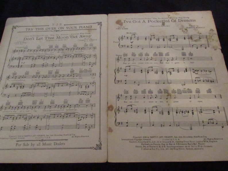 May include: A vintage sheet music book with two songs: "Don't Let That Moon Get Away" and "I've Got A Pocketful Of Dreams". The sheet music is printed on yellowed paper with black ink. The book is open to the second song, "I've Got A Pocketful Of Dreams".