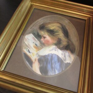 May include: A framed painting of a young girl in a blue dress reading a book. The painting is set in an oval frame and has a brown background.