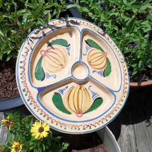 Puede incluir: Un plato de servir de cerámica vintage con un diseño dividido. El plato está decorado con motivos florales pintados a mano en amarillo, naranja, verde y azul.