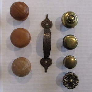 Puede incluir: Surtido de ocho pomos y tiradores para armarios en varios estilos. Tres pomos de madera con acabado de veta de madera natural, tres pomos de latón con acabado pulido y dos tiradores de latón con diseño decorativo.