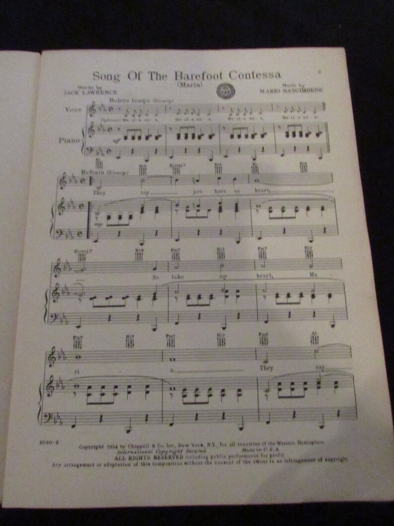 May include: A sheet music score for the song "Song of the Barefoot Contessa" by Jack Lawrence and Mario Nascimbene. The music is written in standard notation with lyrics printed below the musical notes. The title of the song is printed in large, bold letters at the top of the page.