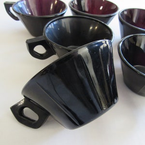 May include: Set of six black and purple glass cups with a flared design. The cups have a glossy finish and are perfect for serving coffee, tea, or other beverages.