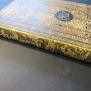 Pu&ograve; includere: Un libro vintage con una copertina dorata e lettere nere. Il titolo del libro &egrave; "The Book of Knowledge".