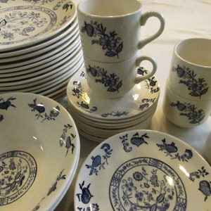 May include: A set of white and blue floral patterned ceramic dinnerware. The set includes plates, bowls, and cups.