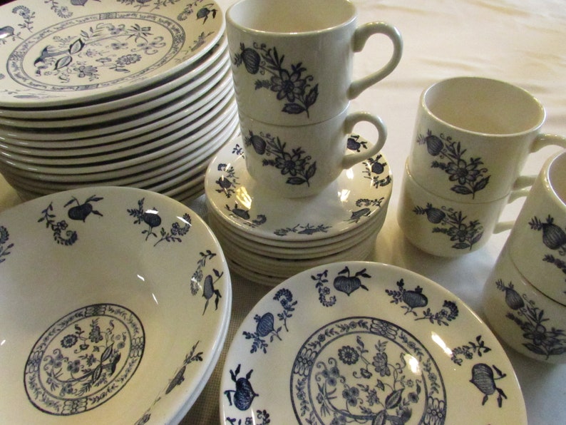 May include: A set of white and blue floral patterned ceramic dinnerware. The set includes plates, bowls, and cups.