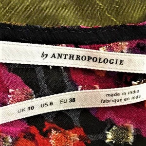 Może przedstawiać: Biała metka z czarnym tekstem "by Anthropologie" i biała metka z czarnym tekstem "UK 10 US 6 EU 38 made in india fabriqu&eacute; en inde"