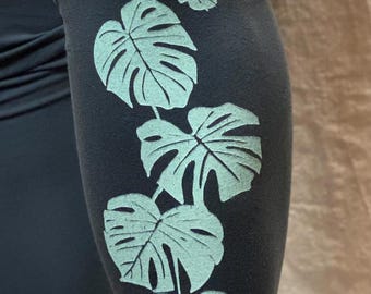 Puede incluir: Leggins azul oscuro con estampado de hojas de monstera verde claro.