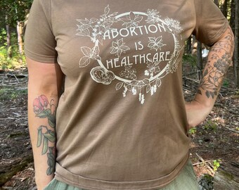 El aborto es atención médica. Camiseta de mujer con estampado herbal. Todas las ganancias se donan.
