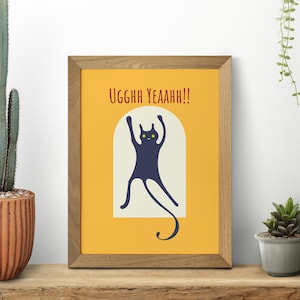 以下が含まれることがあります： 黄色い背景に黒い猫が腕を上げていて、赤い文字で「UGGHHH YEAANHH!!」と書かれた額装されたプリントです。猫は黄色い目をしています。