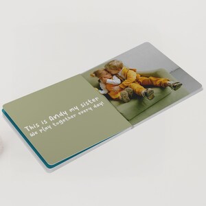 May include: Open book with a photograph of two children hugging on a green couch. The left page has the text: "This is Andy my sister We play together every day!" The book has a teal border.