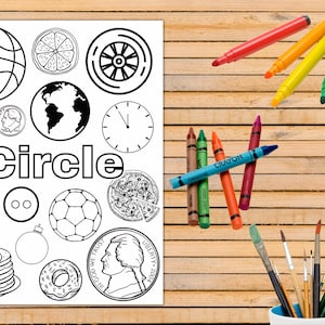 May include: A black and white coloring page with the word "Circle" in large letters. The page features various objects that are circles, such as a basketball, a clock, a pizza, a donut, and a coin. There are also crayons and paintbrushes on a wooden surface.