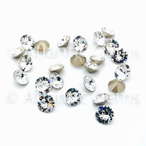 May include: A scattering of clear glass rhinestones with a silver backing. The rhinestones are round and have a faceted design.