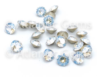 May include: A scattering of light blue iridescent glass rhinestones with silver settings.