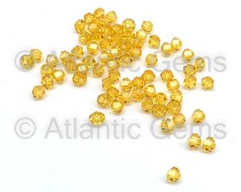May include: A scattering of small, faceted, amber-colored glass beads. The beads are round and have a slight sparkle.