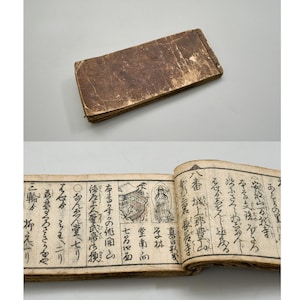 May include: A rectangular, weathered brown leather-bound book shown closed and open. The interior pages feature aged, off-white paper with vertical columns of traditional Japanese calligraphy and small, detailed black ink illustrations of temples.