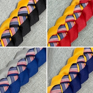 May include: Braided ribbon leis in four color combinations: yellow and black, red, gray and blue, and yellow and navy blue. Each lei incorporates a ribbon with American flags.