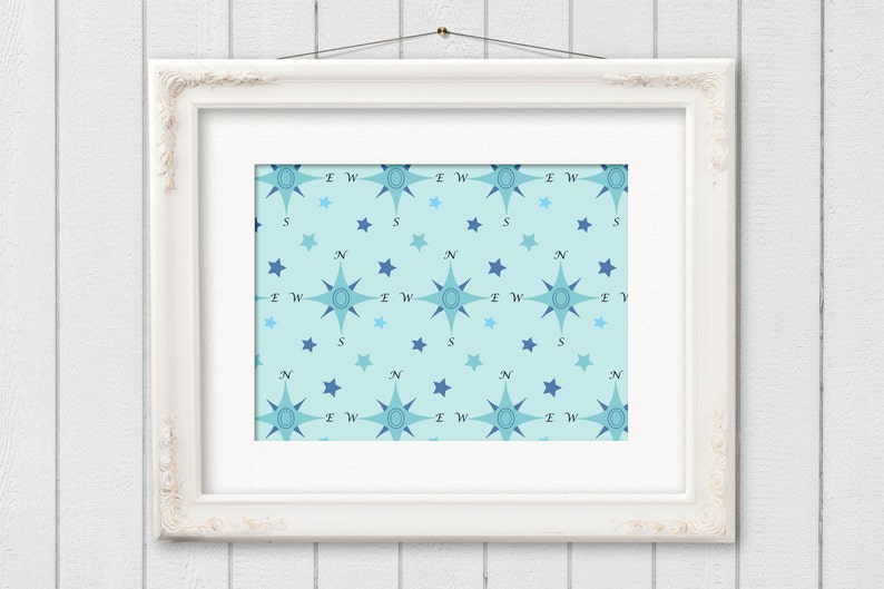May include: A framed print featuring a repeating pattern of compass roses and stars in shades of blue on a light blue background. The compass roses are oriented with the cardinal directions labeled. The frame is white and ornate.