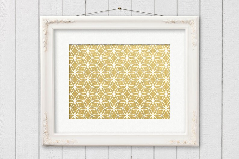 May include: A white frame with a gold geometric pattern inside. The pattern is made up of overlapping circles and is reminiscent of a flower.