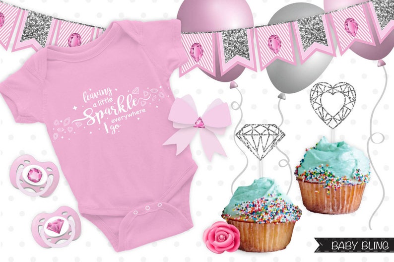 May include: Pink baby onesie with the text "leaving a little sparkle everywhere I go" and silver glitter diamond and heart cupcake toppers. The onesie is surrounded by silver glitter and pink diamond decorations.