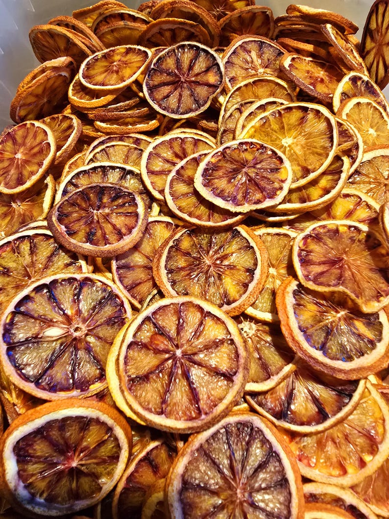 May include: A bowl filled with dried orange slices. The slices are a deep orange colour with a brown hue. They are arranged in a random pattern.