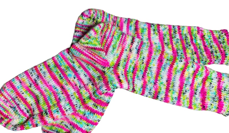 Puede incluir: Un par de calcetines a rayas de colores en tonos de rosa, verde, blanco y negro. Los calcetines est&aacute;n hechos de un tejido suave y de punto.