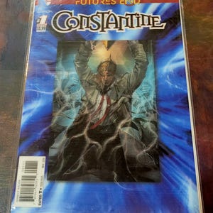 Puede incluir: Portada de cómic con un hombre con una camisa blanca y una chaqueta negra, sobre un fondo azul y blanco. El título del cómic es "Constantine" y el texto "The New 52 Futures End" está en la parte superior de la portada. El cómic es el número 1 y cuesta 3,99 €.