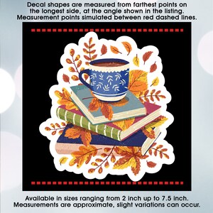 May include: A blue coffee mug with a white design sits on top of a stack of four books. The books are decorated with autumn leaves. The image is surrounded by a white border.