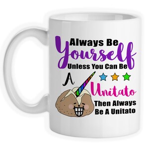 May include: White ceramic coffee mug with a purple, black, and pink graphic that says "Always Be Yourself Unless You Can Be A Unitato Then Always Be A Unitato". The graphic also includes a cartoon potato with a rainbow unicorn horn and three stars.