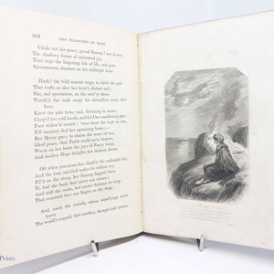 May include: An open book with a black and white illustration of a woman sitting on a cliff overlooking the ocean. The book is titled "The Pleasures of Hope" and includes a poem about a woman grieving the loss of her lover.