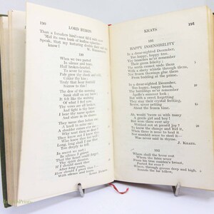 May include: An open book showing poetry by Lord Byron and Keats. The book has a green cover and a red ribbon bookmark. The pages are aged with visible text.
