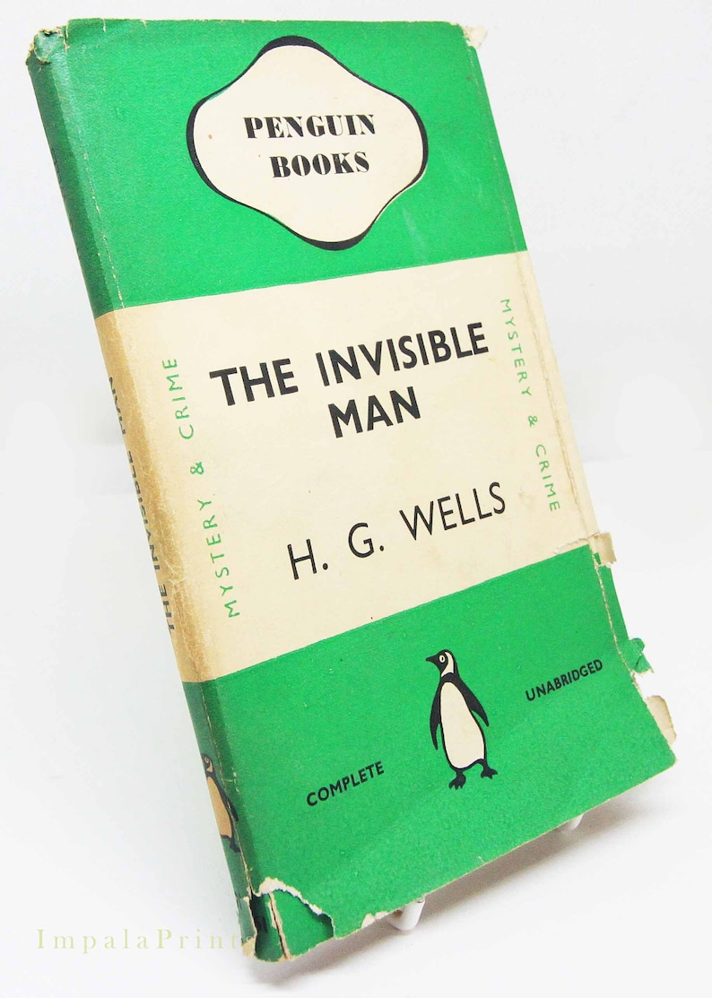 Op de afbeelding: Vintage paperback boek getiteld "The Invisible Man" van H.G. Wells. Het boek heeft een groene kaft met het Penguin Books logo en een pingu&iuml;n illustratie. Het is gelabeld "Mystery & Crime" en "Unabridged".