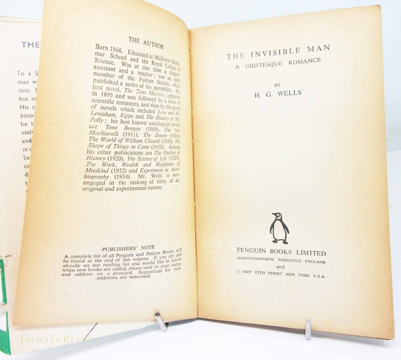 Op de afbeelding: Open boek getiteld "The Invisible Man" van H.G. Wells, uitgegeven door Penguin Books Limited. De biografie van de auteur staat op de linkerpagina. Het boek wordt opengehouden met een metalen standaard.