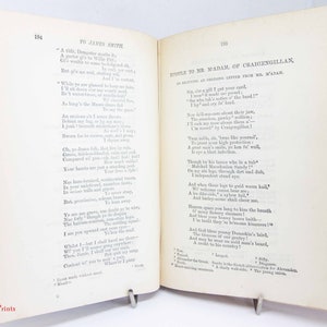 Pode incluir: Um livro antigo aberto com p&aacute;ginas cor de creme e texto impresso em preto. A p&aacute;gina esquerda intitula-se To James Smith e a direita Epistle to Mr. M'Adam, of Craigengillan. O livro tem uma lombada vermelha e bordas vis&iacute;veis.
