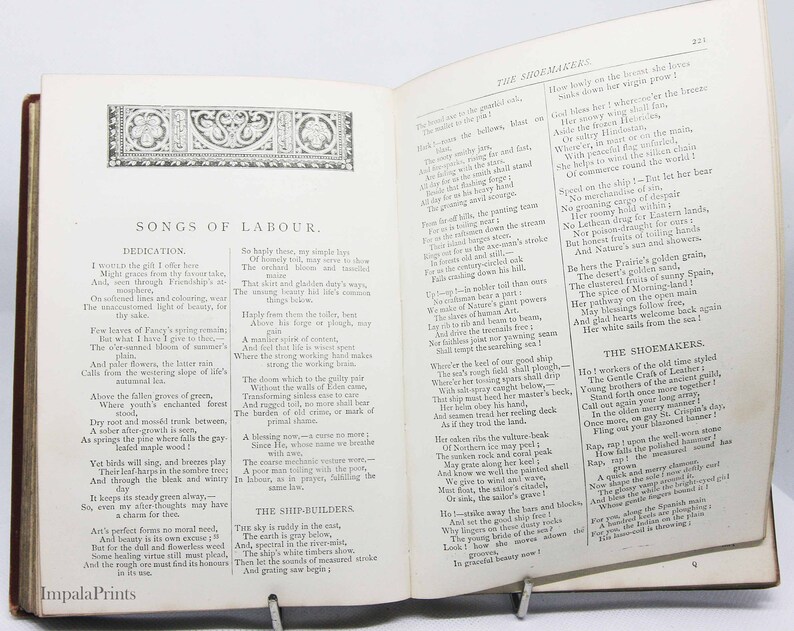 May include: An open book with a yellowed page, featuring a poem titled "Songs of Labour." The poem is about the dedication of workers in various professions, including shipbuilders, shoemakers, and farmers. The book is bound in red leather with gold accents.