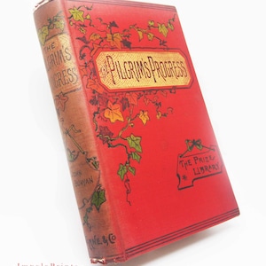 May include: A vintage book titled "The Pilgrim's Progress" with a red cover and gold lettering. The book's spine is brown with gold text and green leaf illustrations. The cover features the title in a gold banner and decorative vines.