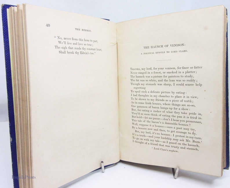May include: A page from a vintage book with a blue cover. The page is filled with text about a haunch of venison. The text is in a traditional font and is written in a formal style. The text includes the phrase "Thanks, my lord, for your venison, for finer or fatter".