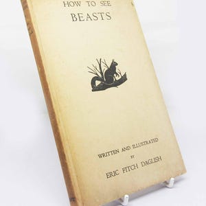 May include: A vintage book titled "How to See Beasts" by Eric Fitch Daglish. The cover features a black and white illustration of a squirrel sitting on a branch.