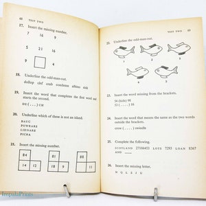 May include: Open book with printed test questions. Pages are yellowed with age. Questions include number sequences, word puzzles, and identifying the odd one out. The text "TEST TWO" is visible at the top of the pages. The Impala Prints logo is at the bottom.