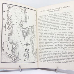 May include: Open book with a sketch map of the Channel Islands on the left page and text on the right. The map is in black and white, with the words "Sketch Map" printed on the left side.