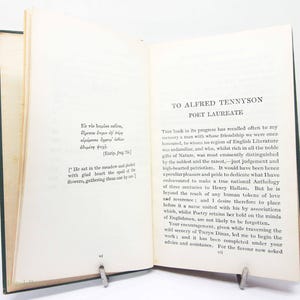 May include: An open book with green covers, held open by a metal clip. The pages are aged and contain printed text in English and Greek. The title "TO ALFRED TENNYSON POET LAUREATE" is visible.