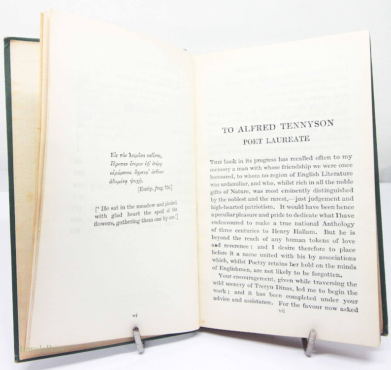 May include: An open book with green covers, held open by a metal clip. The pages are aged and contain printed text in English and Greek. The title "TO ALFRED TENNYSON POET LAUREATE" is visible.