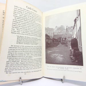 May include: An open book with text and a black and white photograph of a street scene. The text includes the title "Castle Corner" and the phrase "One of many picturesque & quaint corners in St. Peter Port."