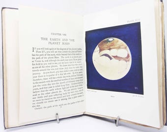 May include: An open book displaying Chapter VIII titled The Earth and the Planet Mars. The left page contains printed text, while the right page features Plate XVII, an illustration of Mars against a dark blue background with white text.
