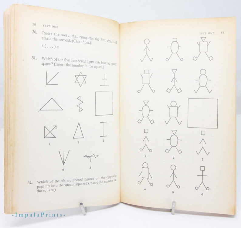 May include: Open book with vintage test questions and geometric shapes. The text reads "TEST ONE" and includes questions about completing words and matching figures. The pages are aged with a visible watermark.