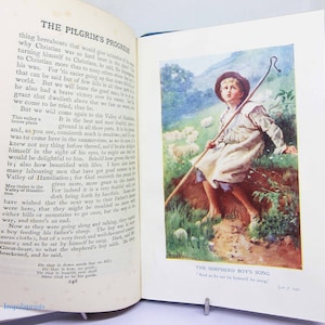 May include: An illustration of a young shepherd boy sitting on a grassy hill, looking up at the sky. He is holding a shepherd's crook and is surrounded by sheep. The text 'The Shepherd Boy's Song' is printed below the image.