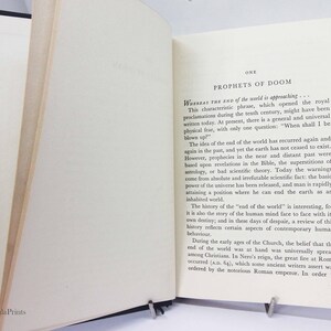 May include: An open book with black covers and cream-colored pages. The text on the right page reads "PROPHETS OF DOOM" and discusses the end of the world. The book is held open by a metal book stand. The Impala Prints logo is visible.