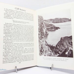 May include: An open book with text and a black and white photograph of a coastal landscape. The text on the left page is titled "Cliff Scenery" and describes the area. The photograph on the right shows cliffs and the sea.
