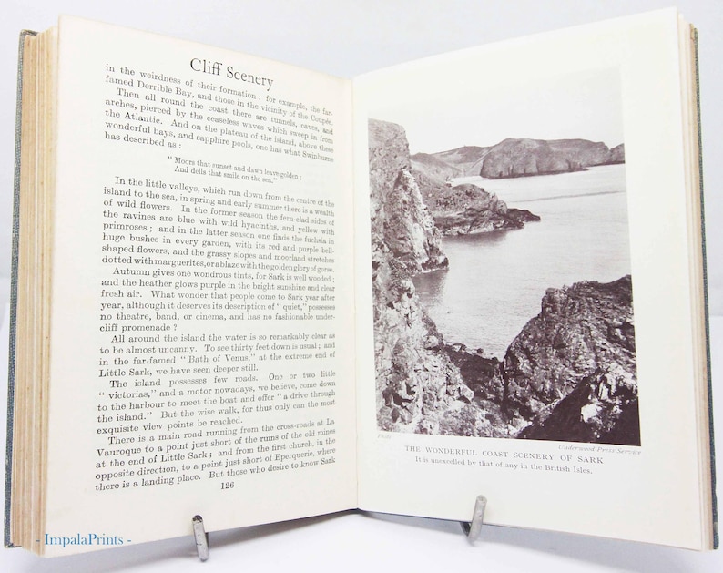 May include: An open book with text and a black and white photograph of a coastal landscape. The text on the left page is titled "Cliff Scenery" and describes the area. The photograph on the right shows cliffs and the sea.