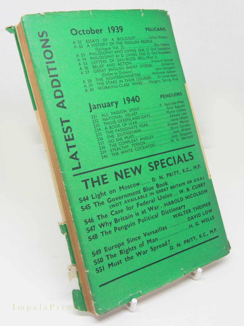 Op de afbeelding: Vintage paperback boek met een groene omslag met titels en auteurs. De omslag leest "Latest Additions" en vermeldt titels uit oktober 1939 en januari 1940. Het boek staat op een witte standaard.